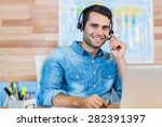 Small photo of Handsome travel agent smiling at camera in the office