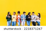 Small photo of Multiracial young friends having fun sharing media content on mobile phone - Millennial diverse people using smart phone together leaning against wall - Social media trends and technology concept