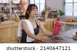 Small photo of gorgeous woman wearing yoga outfit mopping sweat with towel on face and neck. female opening tumbler and taking a gulp of water at dining table. authentic lifestyle