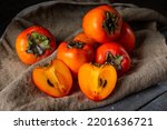 Small photo of ripe persimmon on wooden background. date-plum or sharon fruit. kaki persimmon fruit. Local food