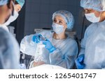 Small photo of Pre oxygenation for general anesthesia. Focused surgeon team operating in an operating theatre, blue filter
