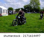 Small photo of 29th May 2022- A classic 1950's Triumph motorcycle bing ridden at vintage show near Newcastle Emlyn, Ceredigion, Wales, UK.