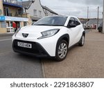 Small photo of 15th April 2023- A stylish Toyota Aygo X Pure VVT-i Auto, five door hatchback car, parked on the main street in the town centre at Pendine, Carmarthenshire, Wales, UK.