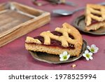 Single slice of pie called 'Linzer Torte', a traditional Austrian shortcake pastry topped with fruit preserves and nuts with lattice design