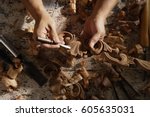 Closeup of hands carving wood.