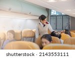 Small photo of Beautiful female flight attendants checking the passengers on safety standard, seat belt, turn off electric devices, seat back and tray table in upright position before airplane take off and landing.