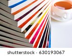 Stack of fiction books with a cup of coffee on white background.