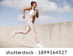 Sports woman running outdoors in the morning. Female athlete in running attire exercising in morning.