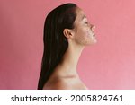 Small photo of Side view portrait of woman with acne inflammation on pink background. Skin disorders lead to depression and insecurities in women.