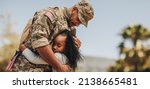 Small photo of Affectionate military reunion between father and daughter. Emotional military dad embracing his daughter on his homecoming. Army soldier receiving a warm welcome from his child after deployment.