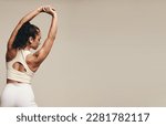 Small photo of Sporty young female working out with muscle-toning stretch exercises in a studio. Athletic young woman striving for better flexibility and balance through regular strength training.