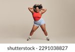 Small photo of Fit woman having a blast as she moves her body in a dance workout session. Sporty woman putting her toned physique and athletic abilities on display as she lets loose with a fun physical activity.