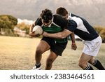 Small photo of Professional rugby players striving to get the ball during the game. Rugby player with ball is blocked by the opposite team player at ground.