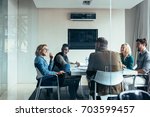 Female manager leads brainstorming meeting in design office. Businesswoman in meeting with colleagues in conference room.