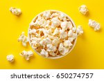 Popcorn viewed from above on yellow background. Flat lay of pop corn bowl. Top view