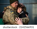 Small photo of Teen son says goodbye to her military father. Son hugs a dad Ukrainian soldier. Ukrainian defender says goodbye to his family. Mobilization of Ukrainian men. War in Ukraine. Defenders of Ukraine