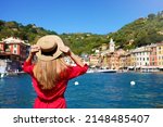 Visiting Portofino, Italy. Travel tourist girl on vacation enjoying view of Portofino harbour. Attractive young romantic woman enjoying view of Portofino picturesque village in Italy.