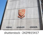 Small photo of Woking, Surrey, UK - June 5, 2016: Woking Borough Council office. Front of the office building with Woking Borough Council writing and coat of arms crest of Woking.