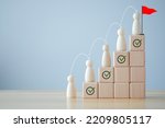 Small photo of Goals achievement and business success. Human improvement. Personal growth and challenge. Rises up stairs to target. Checklist and Step of arrow with wooden figure human ladder up to goal flag.