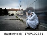 Small photo of Frightened doctor for infectious diseases having mental nervous break down.Coronavirus COVID-19 exhausted physician in fear.Working in improvised medical facility isolation ward.Medical worker stress