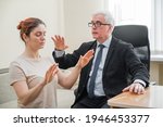Small photo of Mature gray-haired man hypnotizes Caucasian woman during hypnotherapy session. The psychologist uses alternative treatments for the subconscious mind