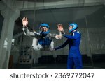 Small photo of A male instructor teaches a woman how to fly in a wind tunnel. Free fall simulator.