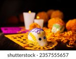 Small photo of Sugar skull with Candles, Cempasuchil flowers or Marigold and Papel Picado. Decoration traditionally used in altars for the celebration of the day of the dead in Mexico