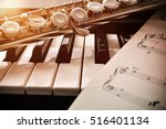 Piano and flute with golden shine and sheet music. Horizontal Composition.Front view