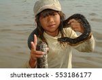 Small photo of SIAM REAP, CAMBODIA, 16 Jan 2008: Cambodian boy with the snake on the Tonle Sap Lake. The people in this district live in appalling conditions, in abject poverty...