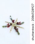 Small photo of Brigid's cross, fir branches, berries in snow. symbol of Imbolc sabbat. ireland handmade amulet made from straw. Wiccan tradition for blessed, protected house. spring and winter pagan festive ritual