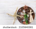 Small photo of Wiccan altar for Imbolc sabbat. pagan festive ritual. Brigid's cross amulet of straw, wheel of the year, snowdrops, witchcraft doll on wooden table. Imbolc holiday, spring equinox. top view
