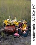 Small photo of wiccan Goddess Candlestick, Copper witch cauldron with flowers, magic candles on meadow, abstract natural background. herb lore, occult. esoteric ritual, witchcraft, spiritual practice. copy space