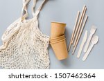 eco natural paper cups, straws, bag flat lay on gray background. sustainable lifestyle concept. zero waste, plastic free items. stop plastic pollution. Top view, overhead, template, Mockup.