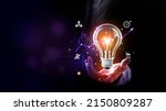 Small photo of Businessman holding a bright light bulb. Concept of Ideas for presenting new ideas Great inspiration and innovation new beginning. Futuristic tone purple, neon color. Analyzing data