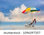 Small photo of deck couch beach chair and woman shawl with gamp umbrella stay together in middle part of the sea water, beautiful and blue in background