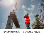 Small photo of worker, foreman, loading master or engineering works while keep talking on mobile phone online, report online speaking on mobile phone, works careless and inattention at risk, high level insurance