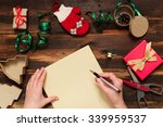 Christmas letter writing on yellow paper on wooden background with decorations