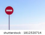 No entry for vehicular traffic. Road sign against blue sky. Space for text. A circular red sign with a white bar indicating 'NO ENTRY' on a grey metal post. road traffic signs.