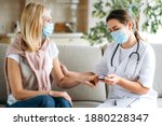 Homehealth care. Woman nurse in a medical mask help middle aged woman during during illness or pressure, female doctor measures the patient's pulse and oxygen saturation using a pulse oximeter