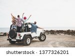 Small photo of Group of friends driving off road convertible car during roadtrip - Happy travel people having fun in vacation - Friendship, transportation and youth lifestyle holidays concept