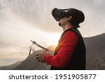 Male professional drone pilot doing fpv experience with virtual reality glasses during sunset time - Technology and innovation concept