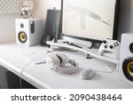 White large gaming headphones are on the table. Close-up in a bright interior