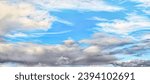 Small photo of Widescreen cloud landscape. Blue sky with gray and white fluffy clouds. Natural real background. Firmament