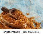 Brown unrefined cane sugar with a spoon close up