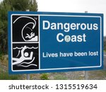 Small photo of Warning sign in blue, black and white advising of the "Dangerous Coast, Lives have been lost".....warn of high waves and undercurrents, especially for swimmers and surf boarders.