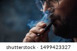 stock-photo-man-smokes-new-vape-pod-system-inhales-and-exhales-vapor-of-electronic-cigarette-vaping-concept-1499423327.jpg