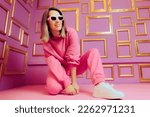 
Cool Trendy Woman Wearing Sunglasses and White Snickers. Fashionable girl wearing athleisure and matching accessories 
