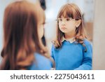 
Little Girl Wearing New Eyeglasses Looking in the Mirror. Adorable fashionable toddler wearing stylish frames in optical store
