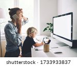Small photo of Modern mom balances between work and child home schooling on sick leave or quarantine. Mother works from home with kid. Woman responding on phone calls, working on computer with a toddler on her lap.