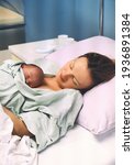 Small photo of Mother and newborn. Child birth in maternity hospital. Young mom hugging her newborn baby after delivery. Woman giving birth. First moments of baby life after labor.